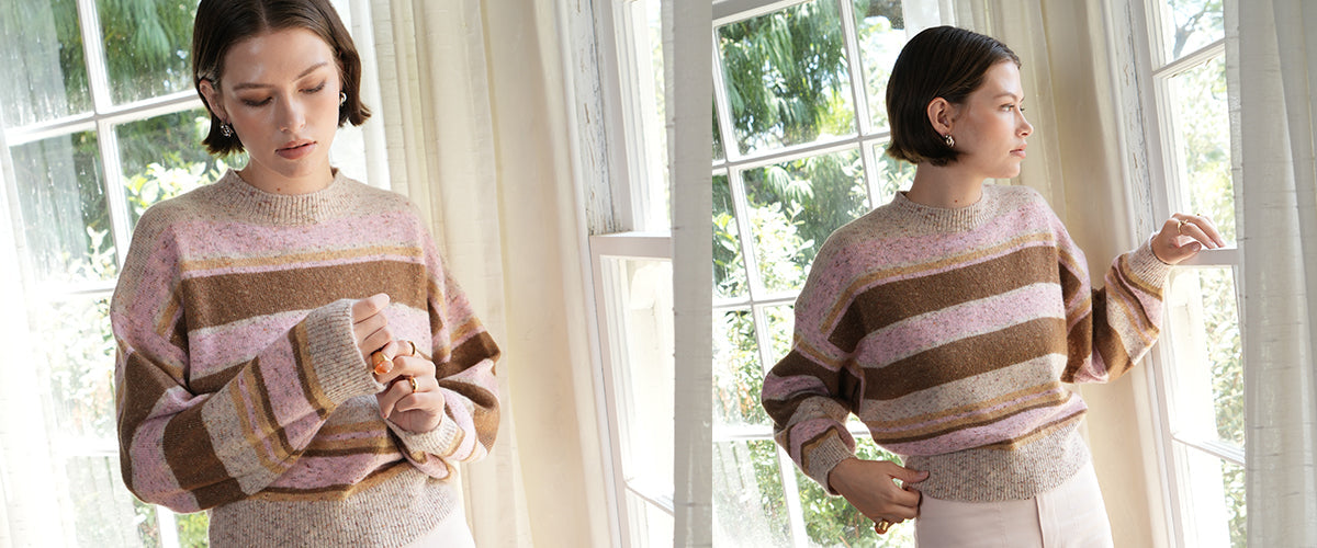 Close-up of an ivory cardigan with an embroidered cherry design on the chest.