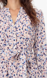 Close up of tie-belt and button-front on the dress with a pink, blue, and purple abstract print.