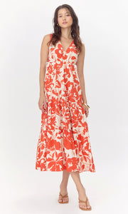 Model wears cream-colored, midi dress with a red, floral pattern. The dress features a V-neckline and drawstrings on the side of the bodice. 