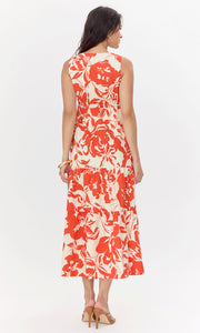 Back view of model wearing cream-colored, midi dress with a red, floral pattern. The sleeveless dress features a tiered skirt.